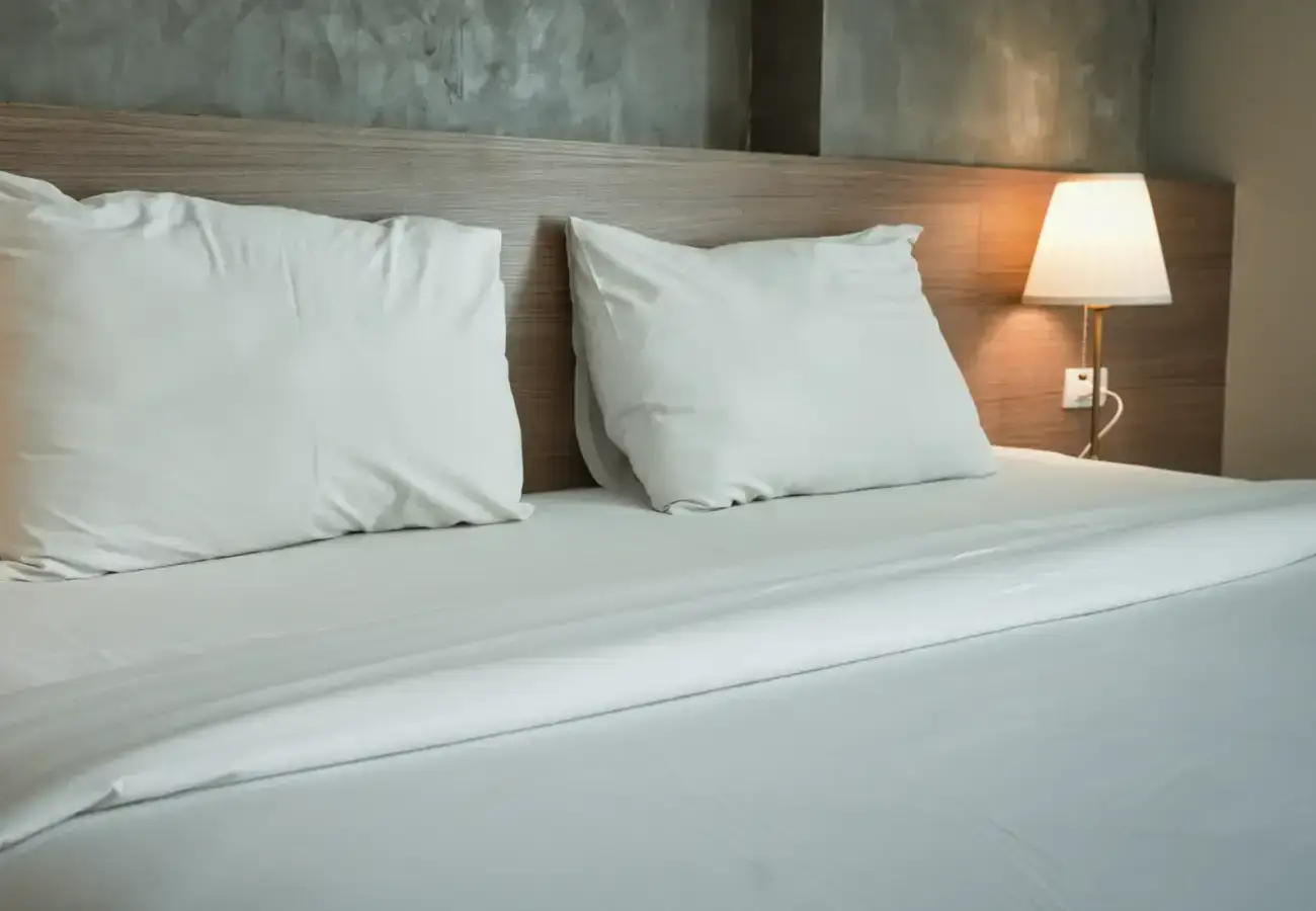 Made-up bed in a hotel room, where bed bugs are often picked up