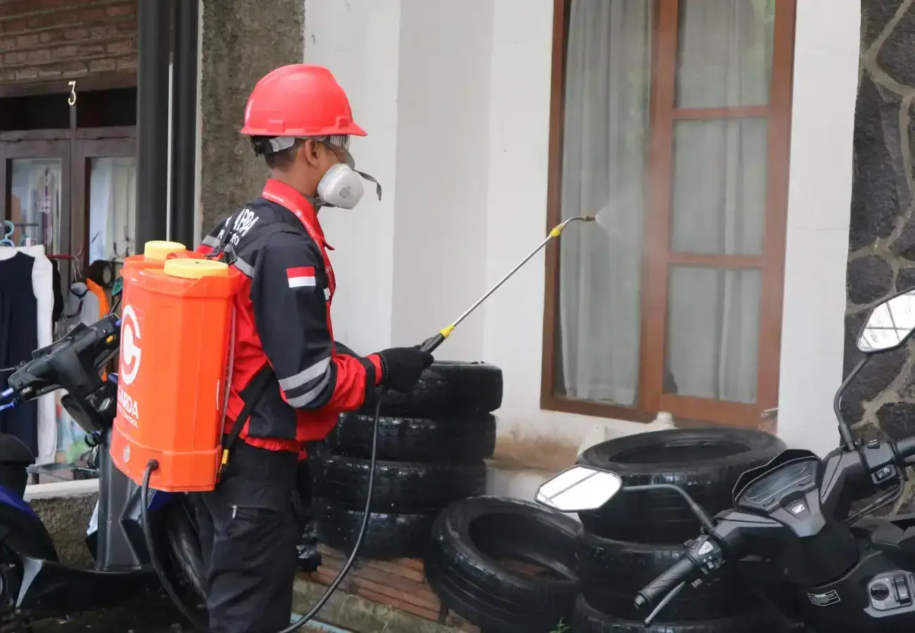 Pest control technician treating the exterior of a home